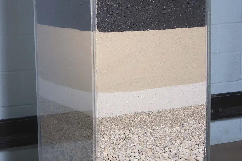 A clear column showing the anthracite, sand and gravel layers of a drinking-water filter